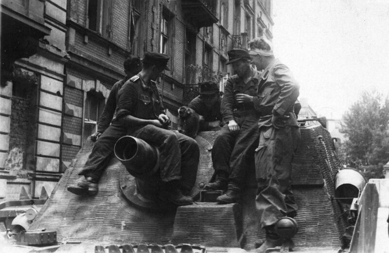 Varsavia 1944. L'equipaggio del cannone semovente tedesco Sturmpanzer IV della Wehrmacht nazista gioca con una scimmia a Varsavia durante la soppressione della rivolta.