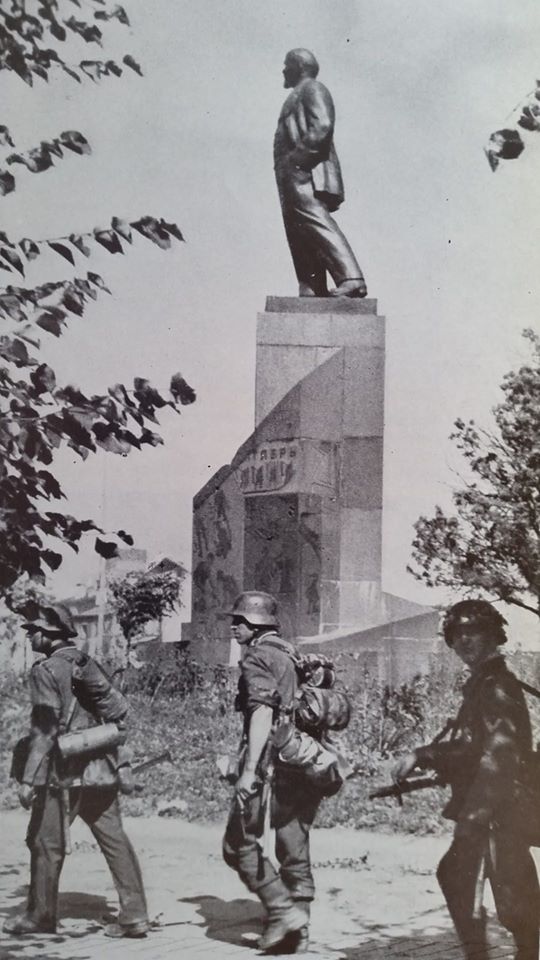 Soldati tedeschi passano accanto a una statua di Lenin a Novgorod