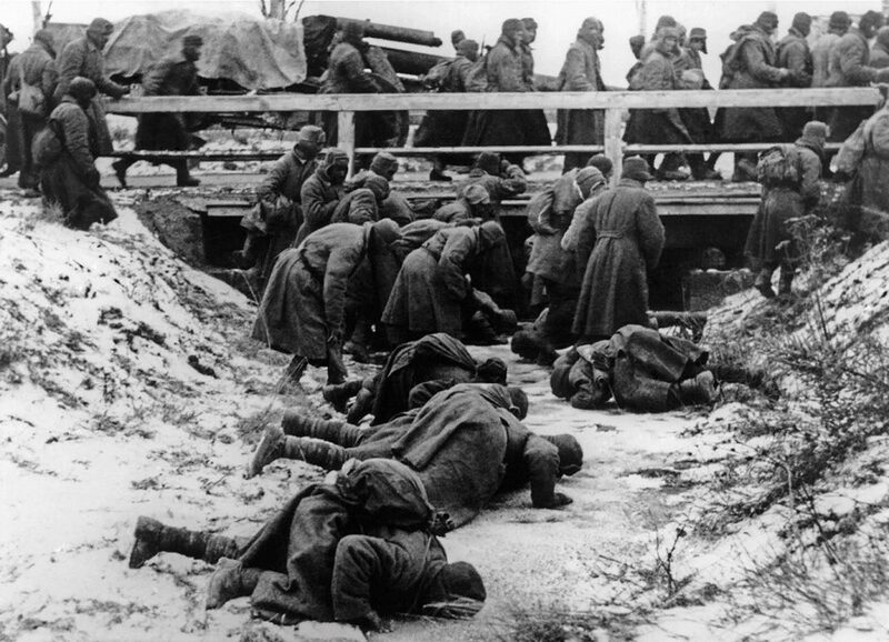 Prigionieri sovietici in marcia bevono da un corso d'acqua ghiacciato.